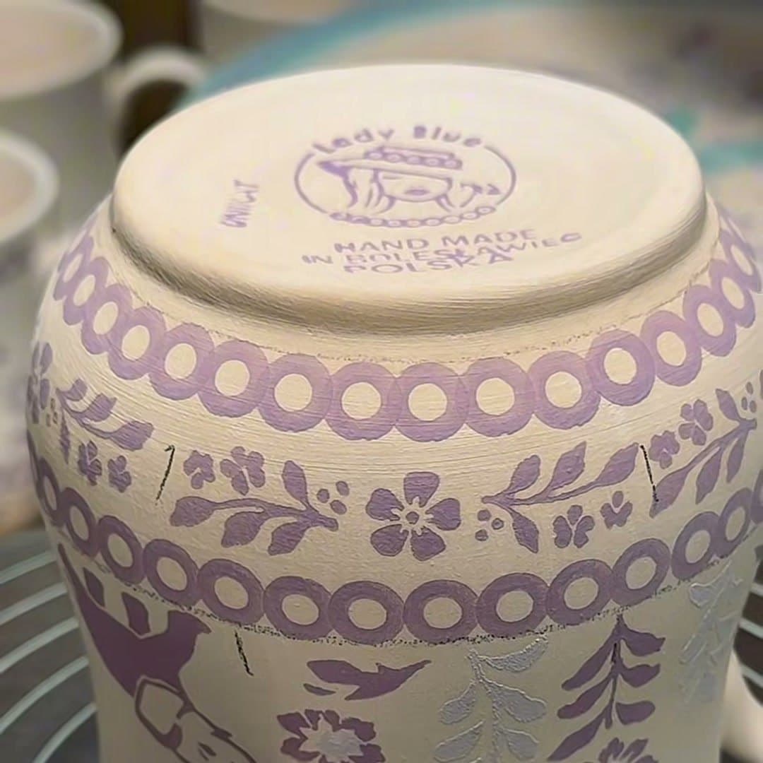 Base of a mug before firing: lilac Lady Blue logo, the words Hand made in Bolesławiec Polska and the UNIKAT stamp